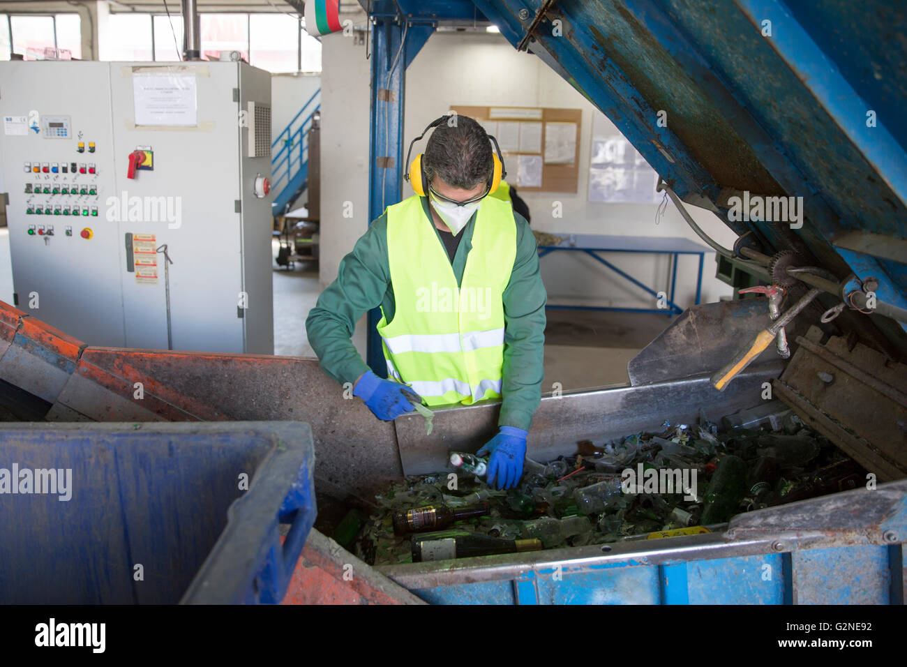 Sofia, Bulgaria - 26 Maggio 2016: Rifiuti di vetro lavoratore è il riciclaggio di bottiglie di vetro in un impianto di riciclaggio. Diversi imballaggi di vetro Foto Stock