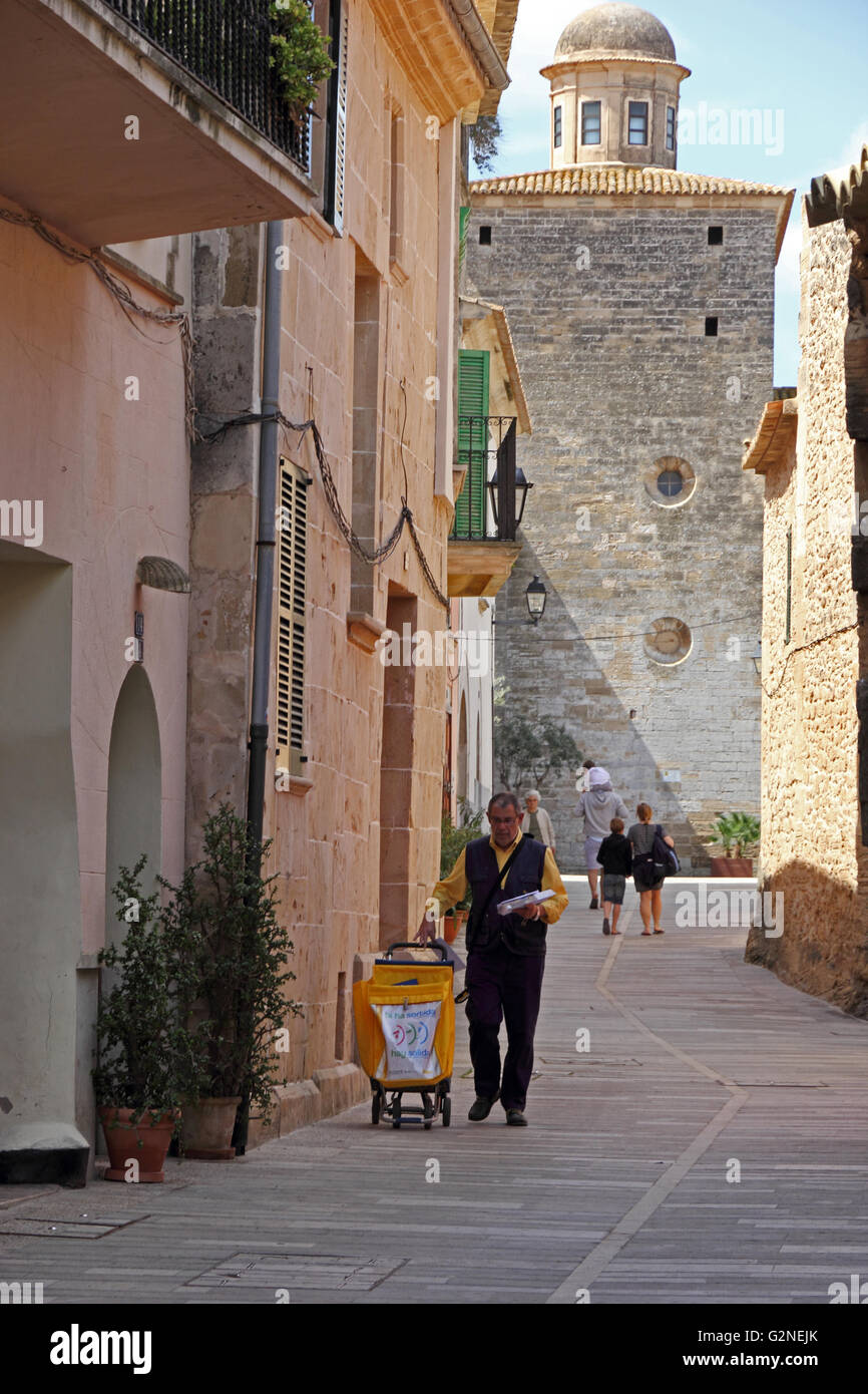 Un postino recapita posta nel centro storico di Alcudia, Mallorca Foto Stock