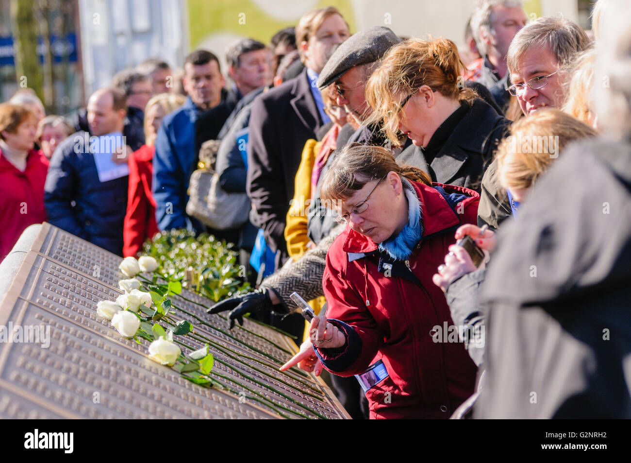 Belfast, Regno Unito. 15/04/2012 - Una folla passato file l'elenco dei nomi delle vittime al centenario del naufragio del Titanic e apertura del Memorial Garden a Belfast City Hall. Foto Stock