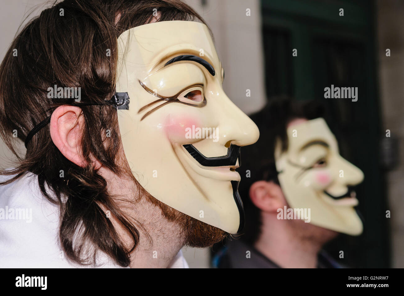 Persone che indossano Guy Fawkes maschere, sinonimo con il gruppo di hacker 'Anonimo' . Belfast 11/02/2012 Foto Stock