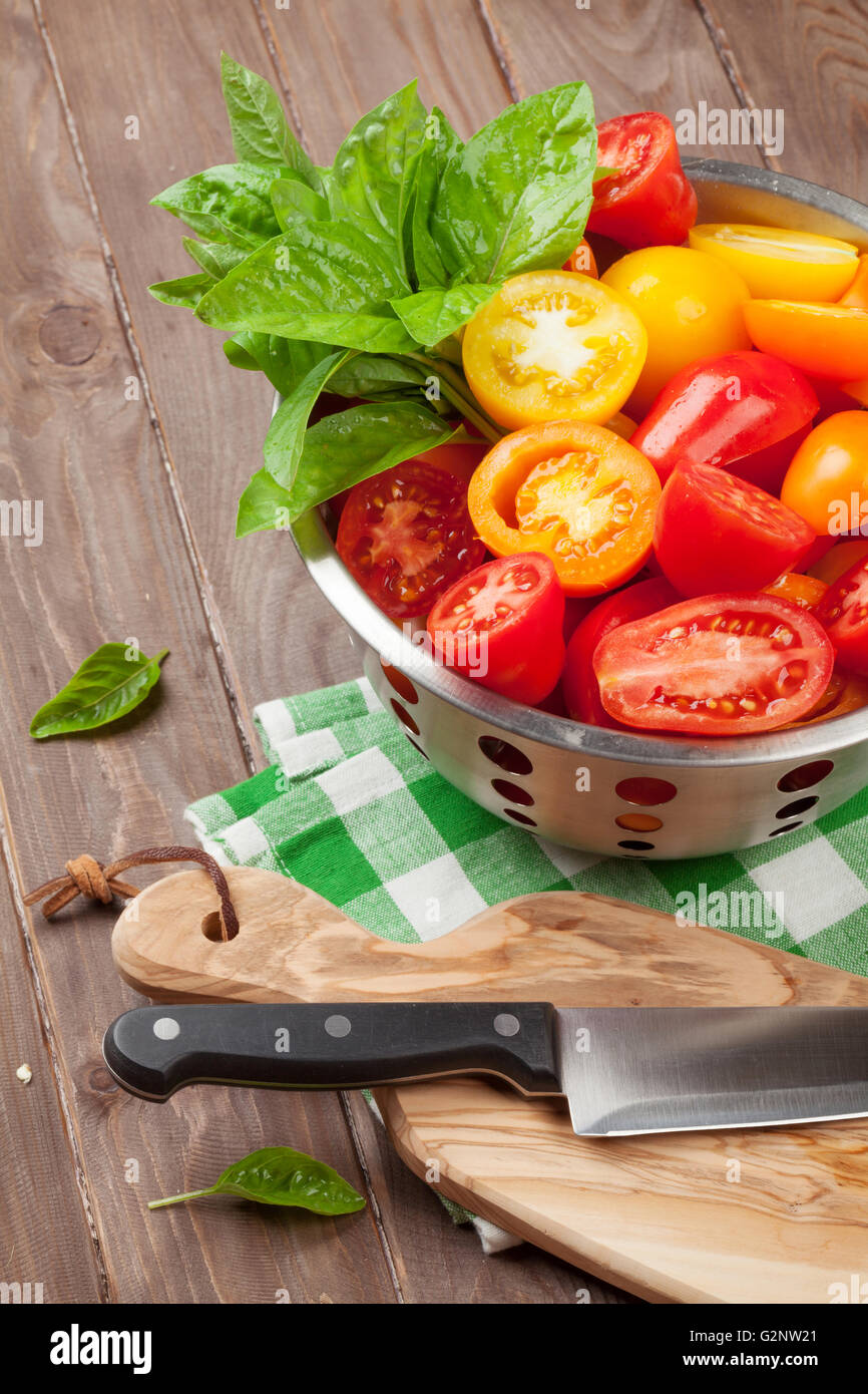 Colorate freschi pomodori e basilico in scolapasta Foto Stock