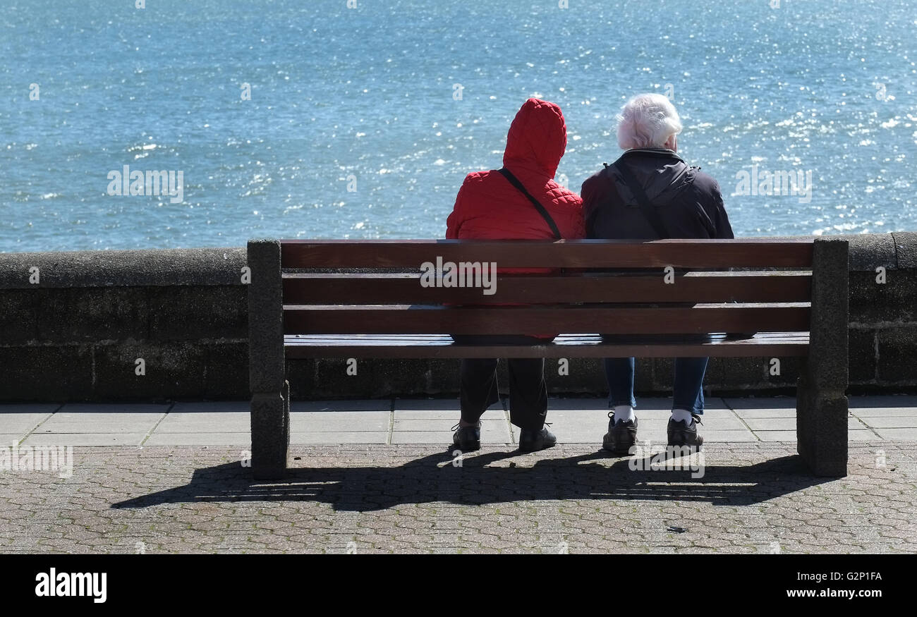 Due persone sul sedile guardando il mare. Foto Stock