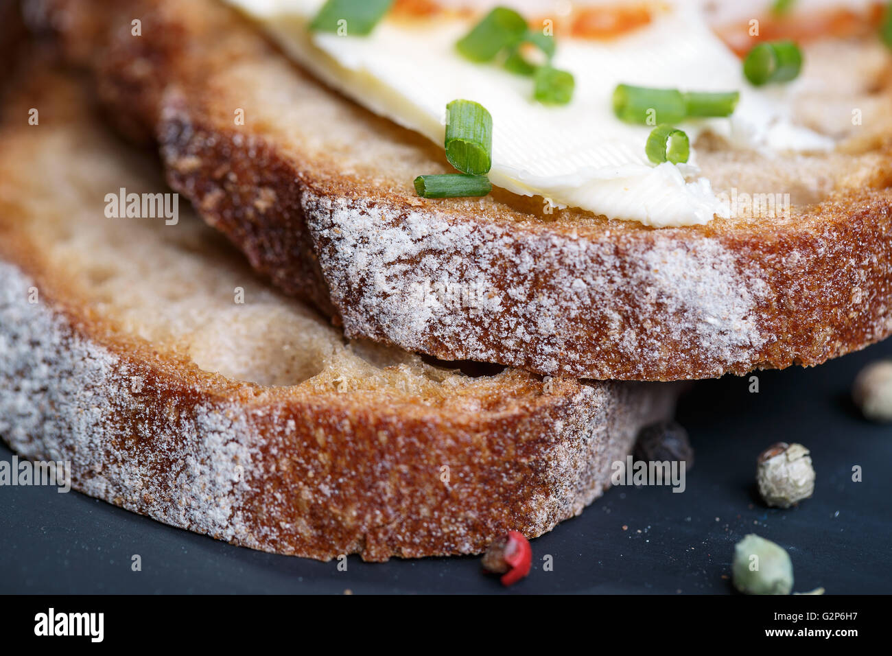 Fette di pane con prosciutto, burro e erba cipollina Foto Stock