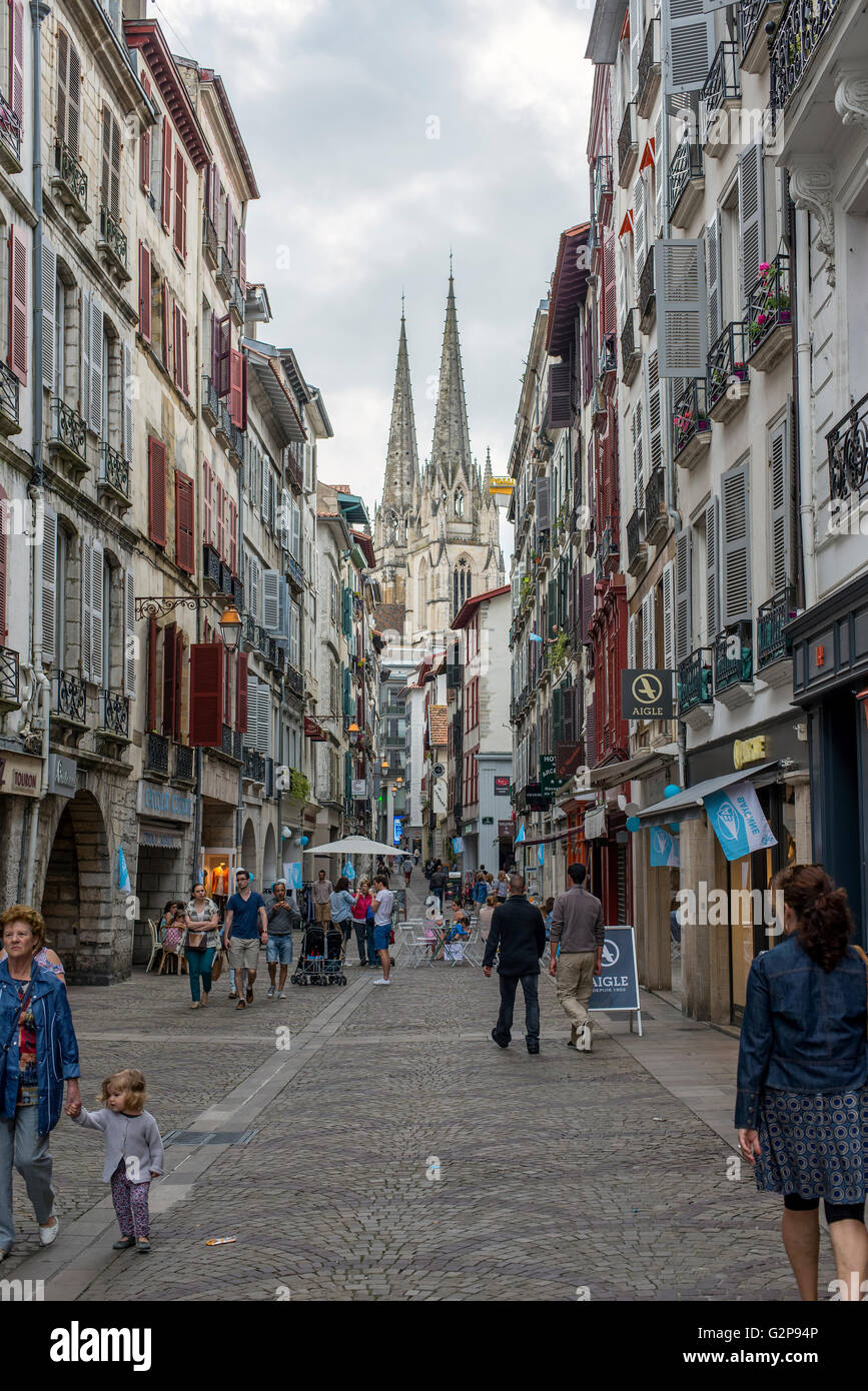 Persone che camminano in Rue Pont Neuf street di Bayonne con la Cattedrale di Sainte-Marie de Bayonne in background. Aquitaine, Francia. Foto Stock
