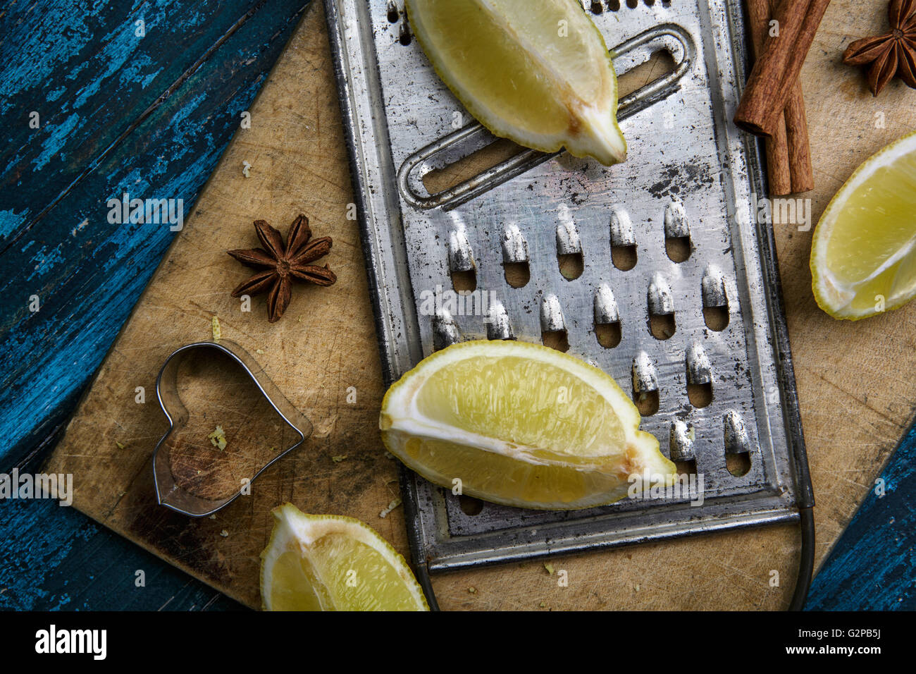Limone fresco con metallo grattugia sulla scheda blu Foto Stock
