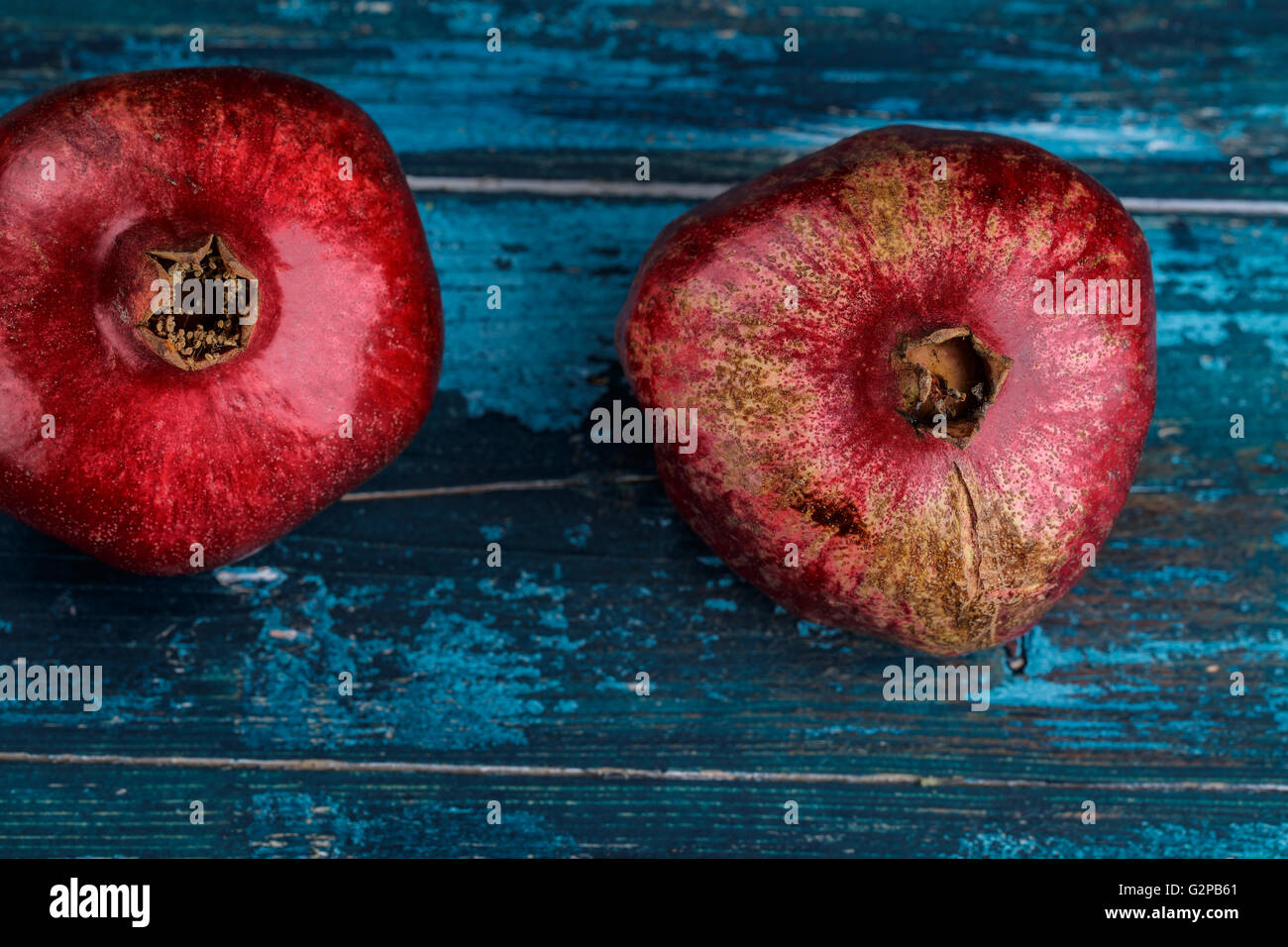 Fresh luminoso rosso melograno blu su sfondo di legno Foto Stock