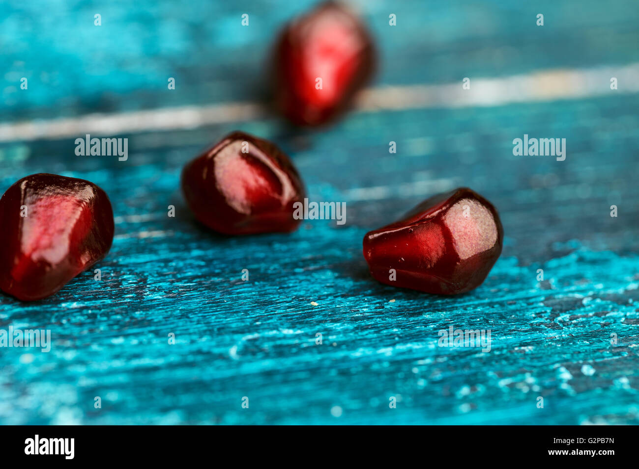 Fresh luminoso rosso melograno Grenadine dei frutti e delle sementi sul blu sullo sfondo di legno still-life studio shot Foto Stock
