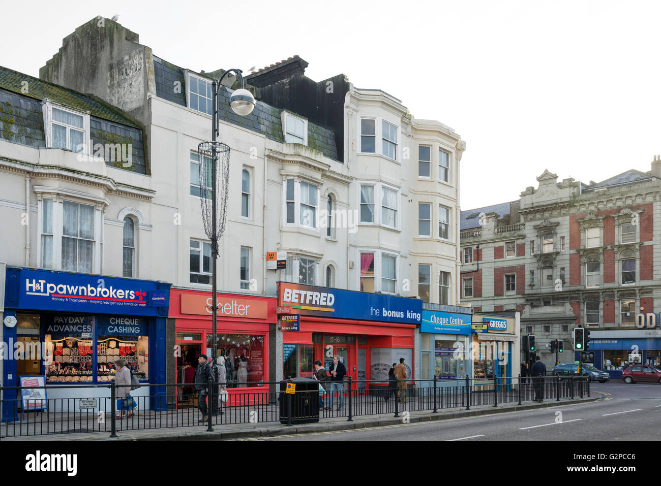 I negozi di Queen's Road includono un pewnbrokers, Shelter, Betfred & Cheque Centre, Greggs. Hastings. East Sussex. Inghilterra. REGNO UNITO. Foto Stock