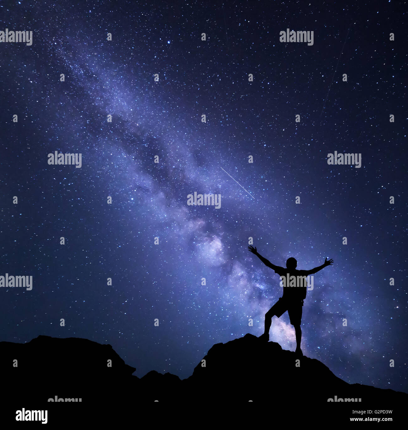 Via Lattea. Cielo notturno con stelle e la silhouette di un uomo felice con zaino e sollevate le armi. Sfondo spazio Foto Stock