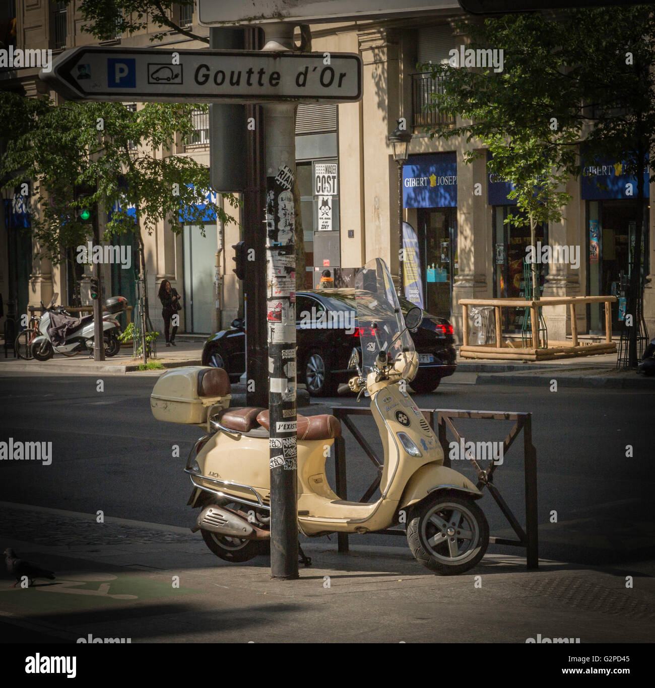 Giallo scooter parcheggiato su un marciapiede in una strada a Parigi Foto Stock