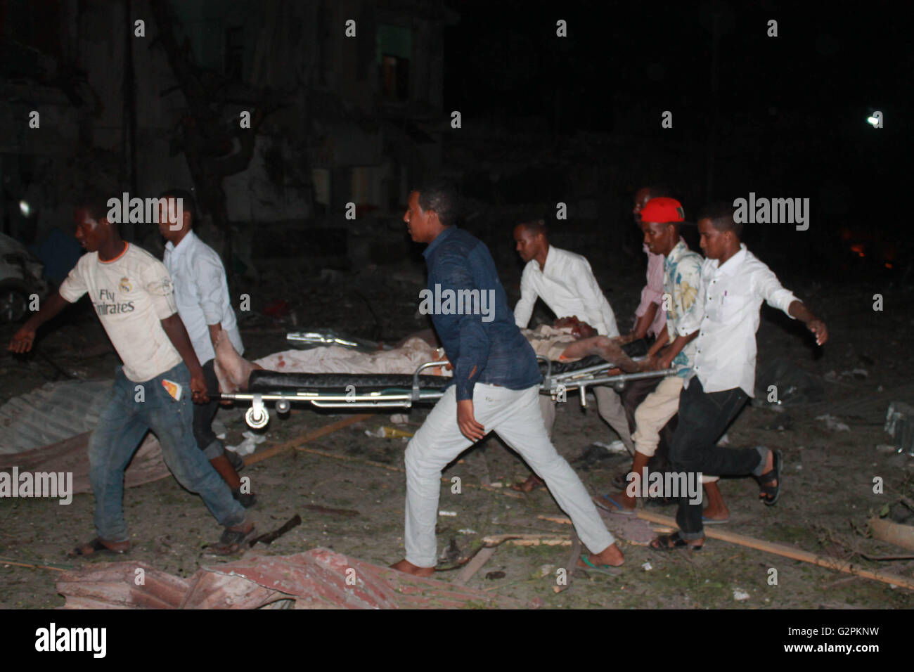 Mogadiscio, Somalia. Il 1 giugno, 2016. Residenti aiuterà a portare una persona ferita vicino al sito di un suicidio attentato all'automobile intrappolata a Ambassador Hotel a Mogadiscio, capitale della Somalia, Giugno 1, 2016. Almeno 10 persone sono state uccise e 25 altri feriti in un attentato da Al-Shabaab sull'Ambassador hotel nella capitale somala Mogadiscio, la polizia ha detto che il mercoledì. Credito: Faisal Isse/Xinhua/Alamy Live News Foto Stock