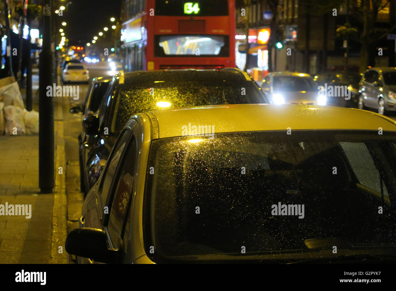 Di notte le luci, la condensa / pioggia sulle automobili parcheggiate sulla strada di Londra Foto Stock
