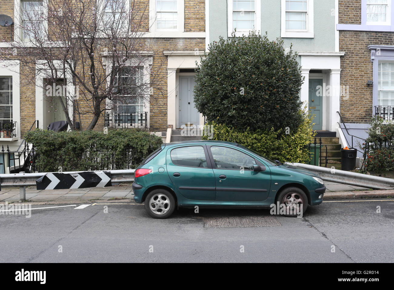 Verde auto contro crash barriera, case Foto Stock