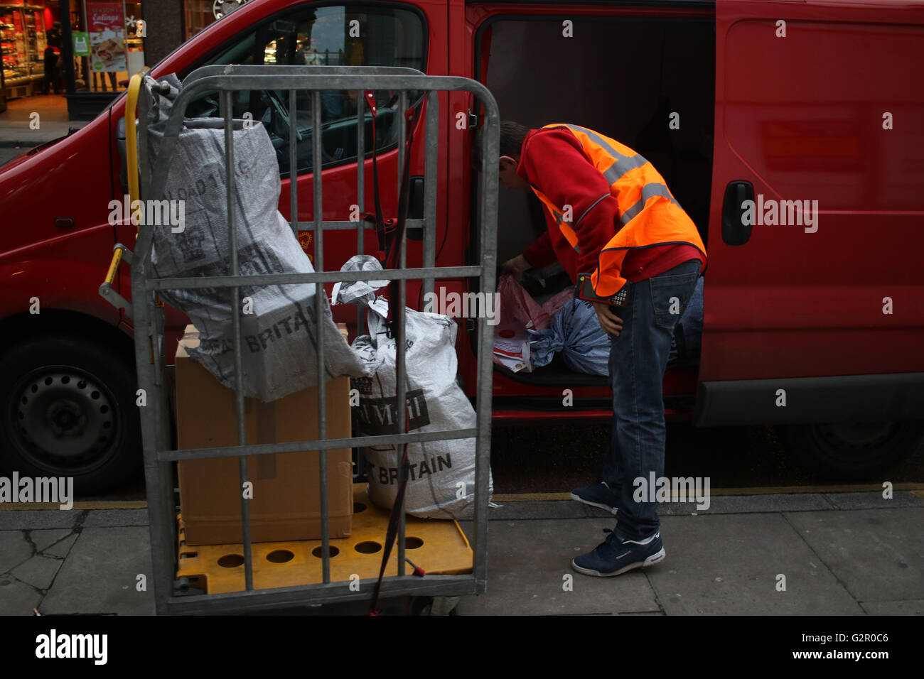Royal Mail post office lavoratore ordina lettere e pacchi in un furgone sull'Archway Road, Londra Foto Stock
