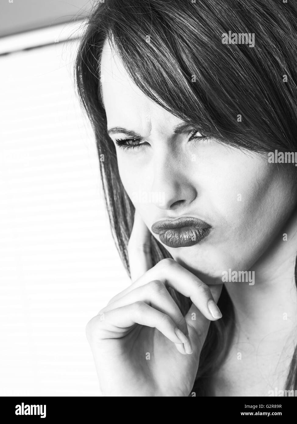 Ritratto in bianco e nero di un frustrato annoiato giovane donna caucasica in stretta fino accigliata e arrabbiato Foto Stock