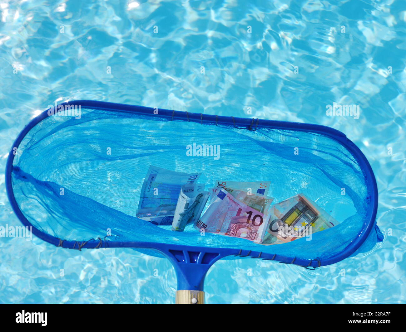 Immergere la pesca con rete da banconote in euro al di fuori dell'acqua, simbolo immagine per il salvataggio dell'Euro Foto Stock