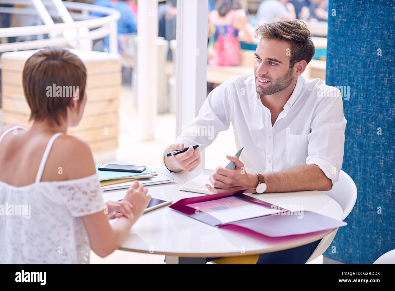 Imprenditore prendendo appunti da la sua femmina business partner in ristorante Foto Stock