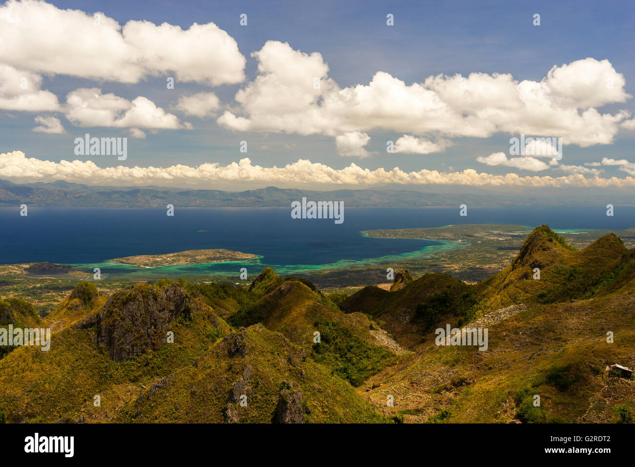 Vista dalla montagna al mare tropicale tra isola filippina sotto nuvoloso cielo blu Foto Stock