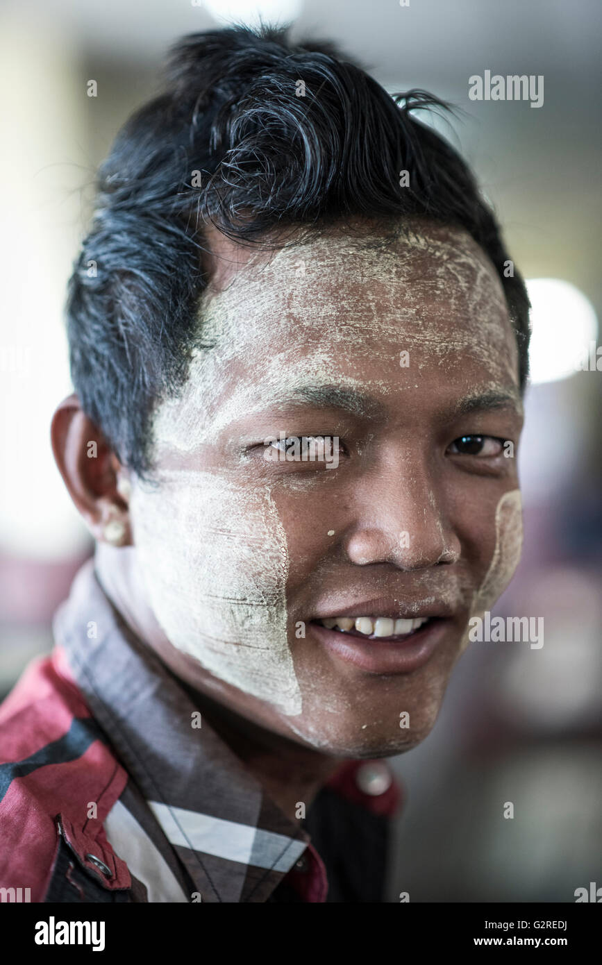 Ritratto di un giovane birmano uomo indossando il tradizionale per il make-up (thanakha) sul suo volto, Yangon, Myanmar. Foto Stock