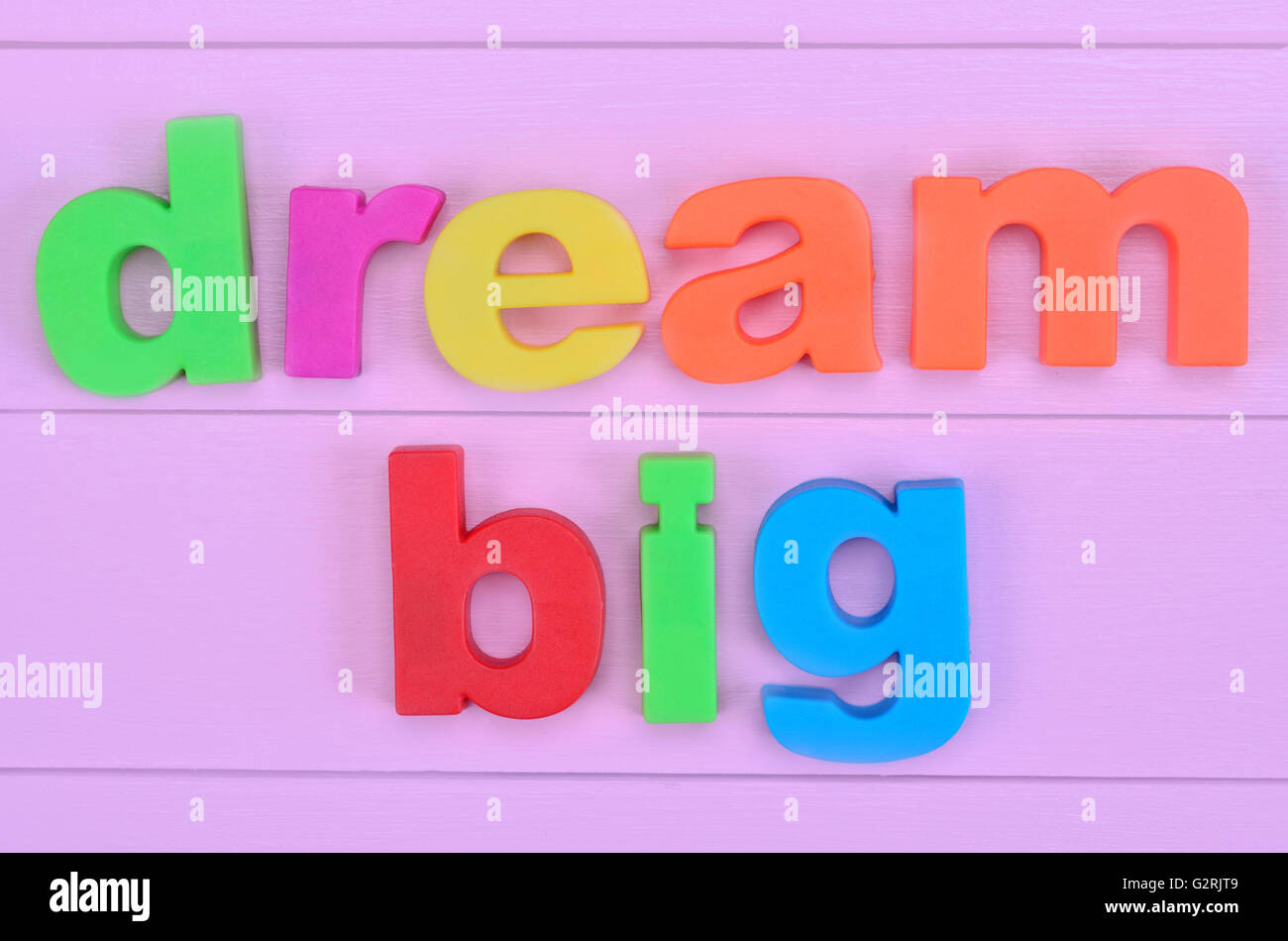 Le parole grande sogno rosa sul tavolo di legno Foto Stock