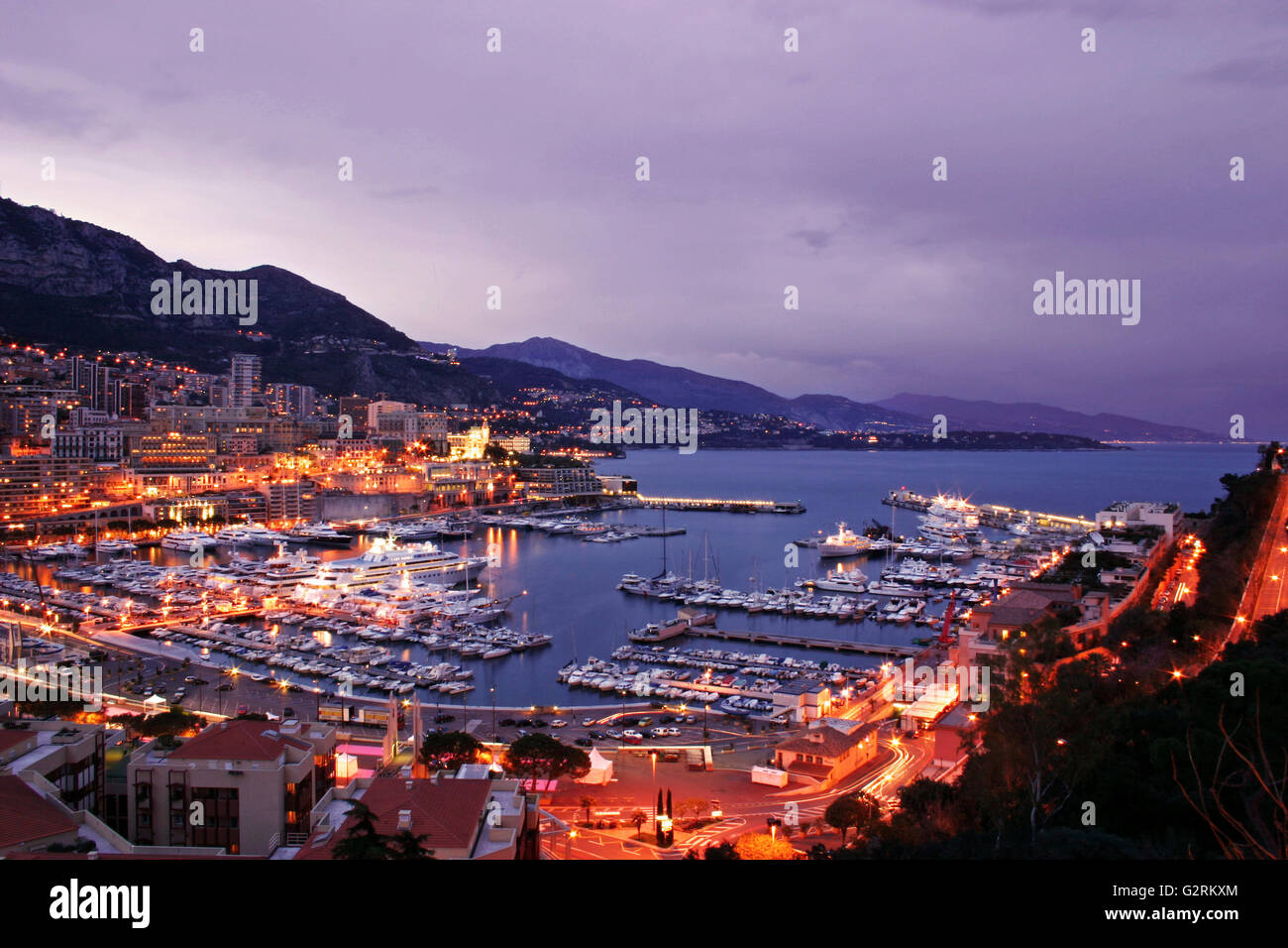 Monaco scenic di notte inclusi lussuosi yacht e il Monte Carlo skyline Foto Stock
