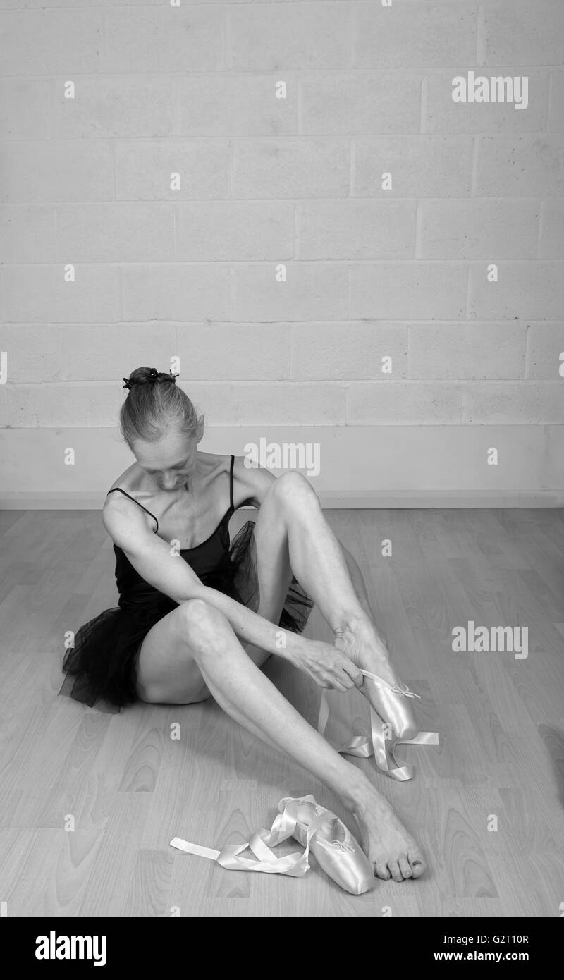 Invecchiamento della ballerina medicazione in suo punto scarpe, indossando solo un tutu. Il 31 maggio 2016 Foto Stock
