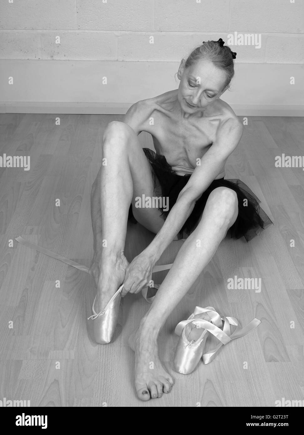 Invecchiamento della ballerina medicazione in suo punto scarpe, indossando solo un tutu. Il 31 maggio 2016 Foto Stock