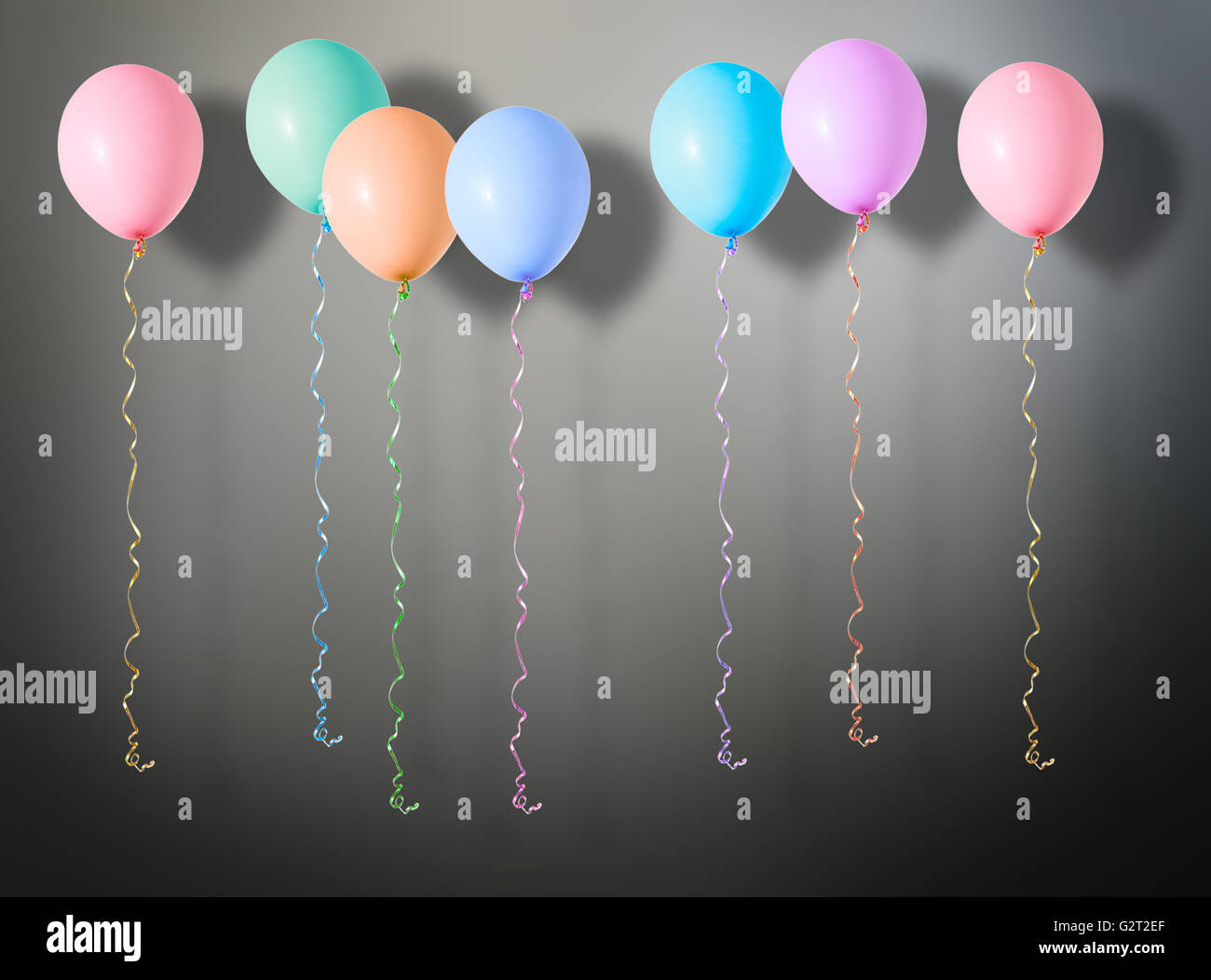 Aria variopinti palloncini volanti su sfondo scuro Foto Stock