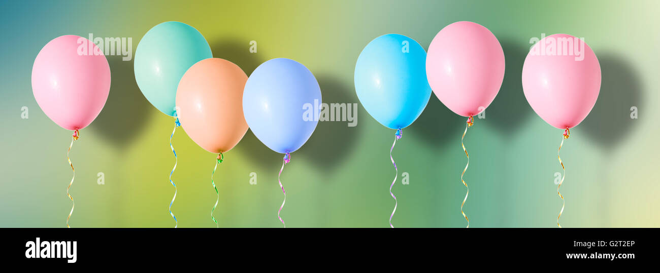 Aria variopinti palloncini volanti su sfondo colorato Foto Stock