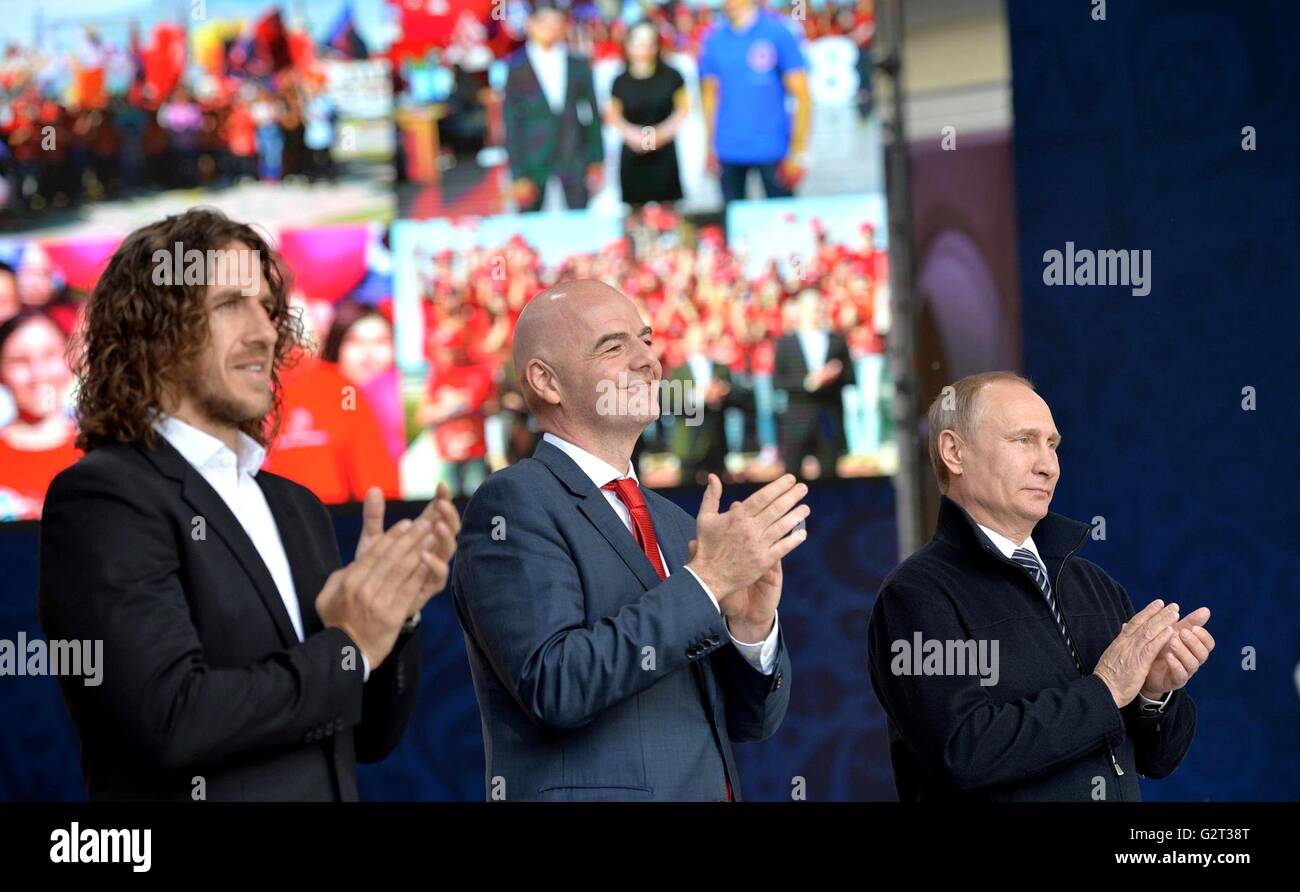 Il presidente russo Vladimir Putin si pone al fianco di FIFA Presidente Gianni Infantino, centro e calcio spagnolo player Carles Puyol durante una cerimonia per il lancio del programma di servizio volontario per il 2017 FIFA Confederations Cup e il 2018 FIFA World Cup Giugno 1, 2016 a Mosca, in Russia. La Russia ospita entrambi i principali eventi e sperare di attrarre 15.000 volontari per assistere con i giochi. Foto Stock