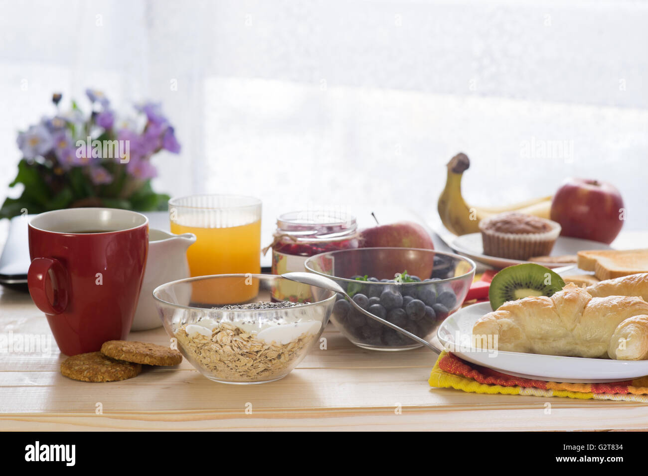 La colazione sul tavolo di legno di mattina di sole Foto Stock