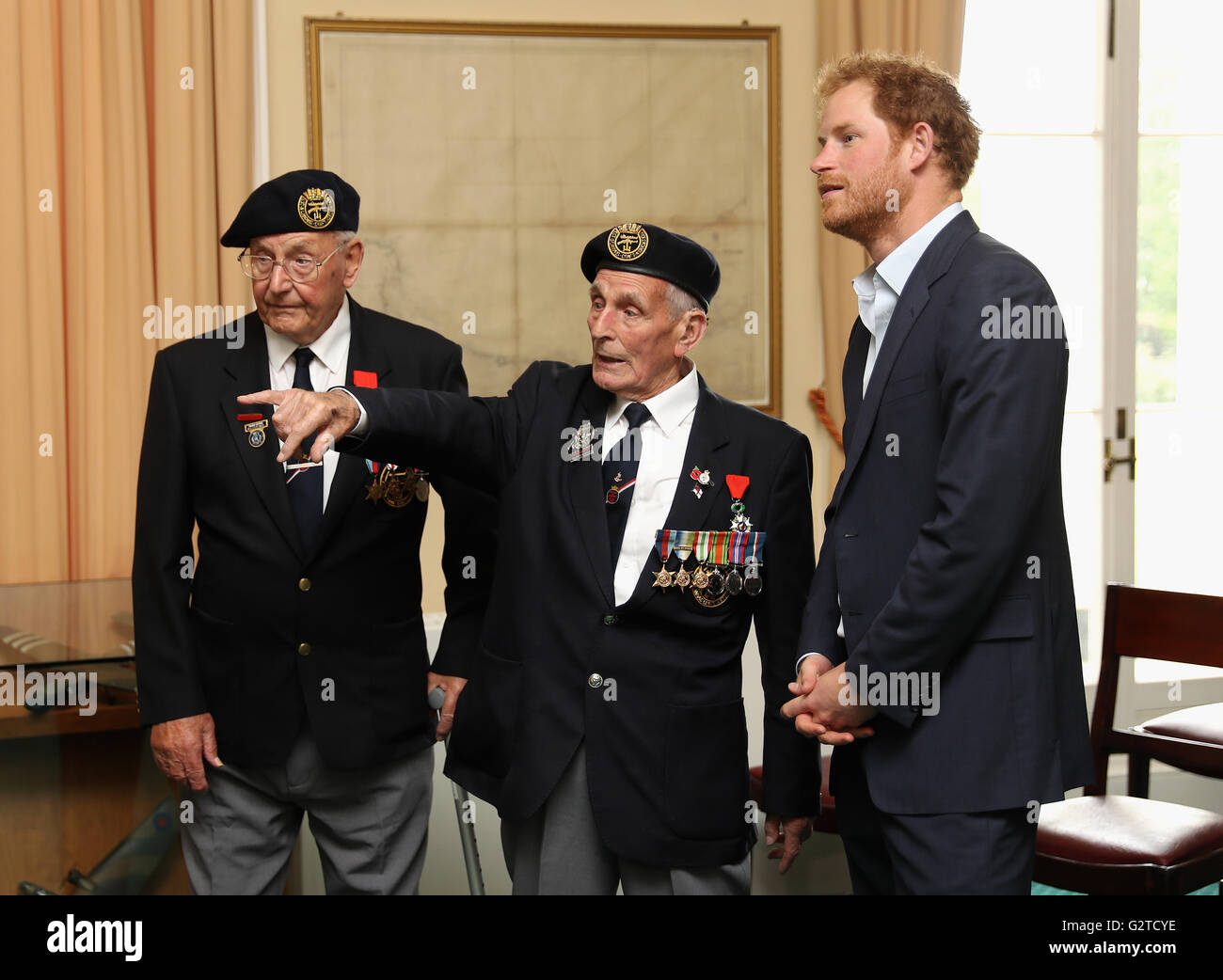 Il principe Harry soddisfa i veterani Giovanni Dennett (centro) e Frank Diffell (sinistra) nella mappa Room durante un ricevimento con i veterani che hanno preso parte al D-Day sbarchi nel 1944, a Southwick House, vicino a Portsmouth, la sede in cui i comandanti alleati previsto lo sbarco in Normandia. Foto Stock