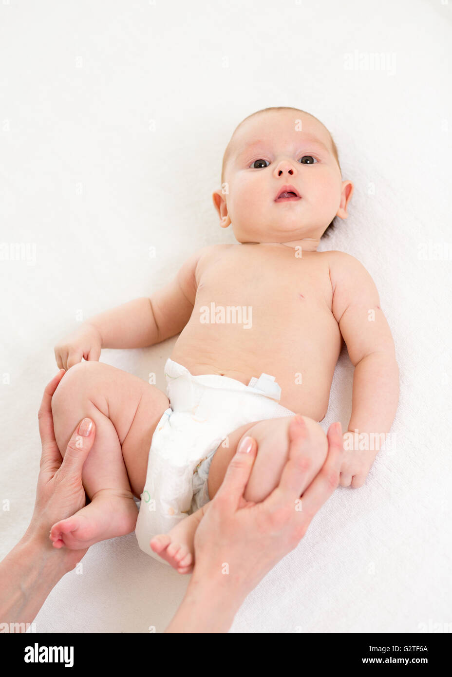 Madre il massaggio e la ginnastica fare il suo bambino neonato Foto Stock