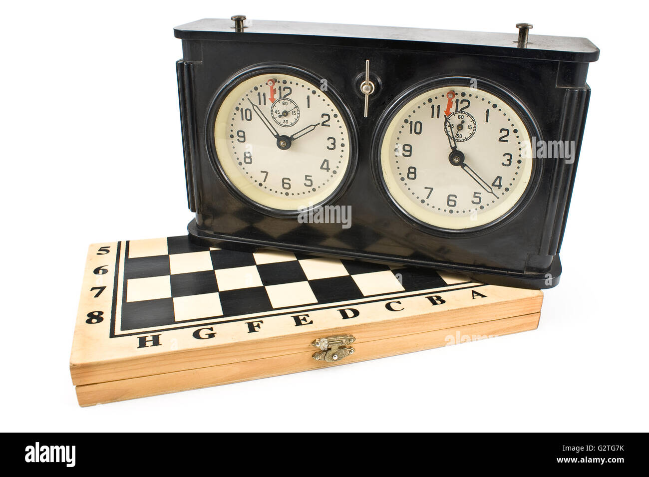 Il vecchio orologio a scacchi sulla scacchiera isolato su bianco Foto Stock