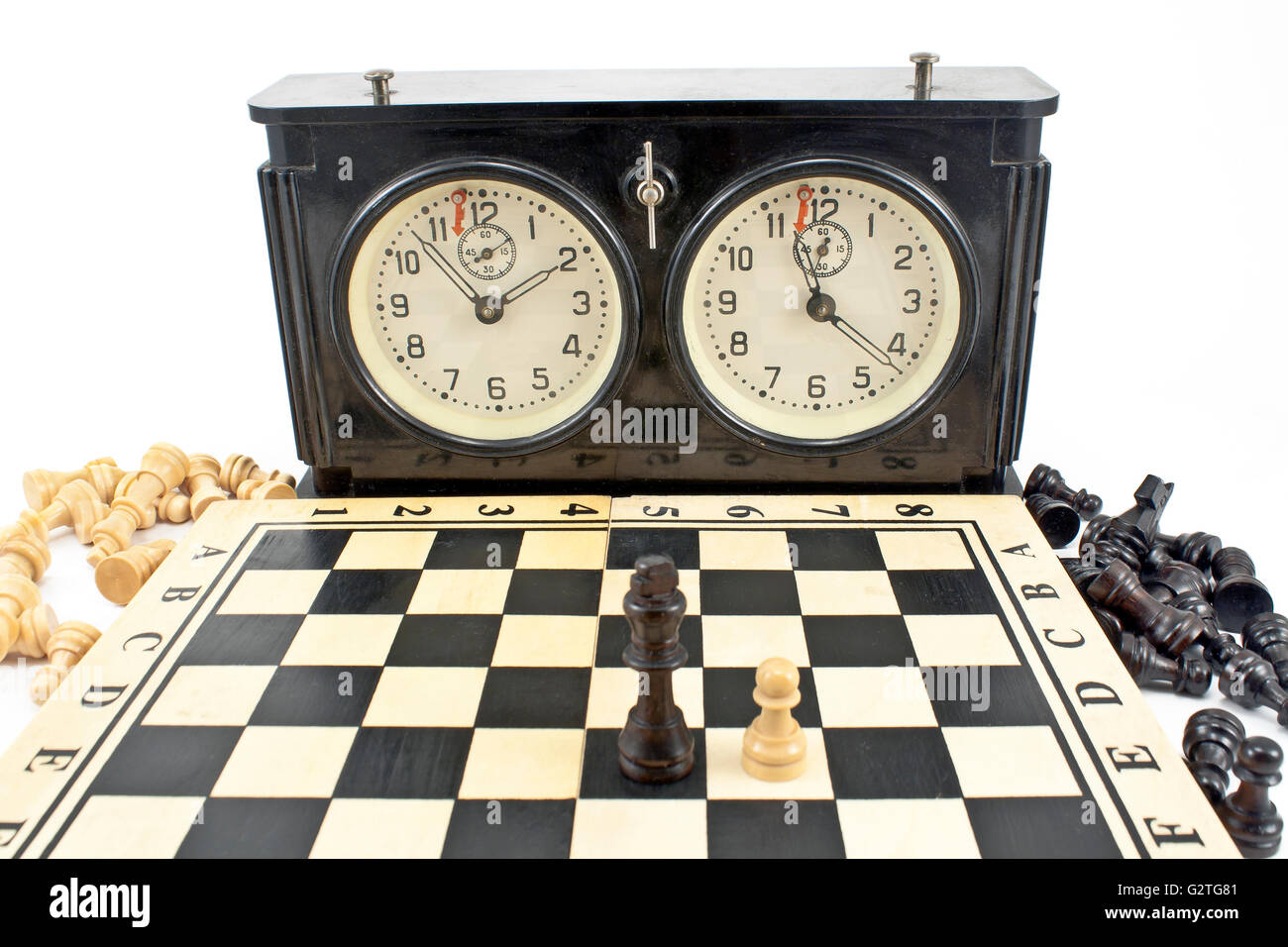 Vecchio orologio scacchi e scacchiera su bianco Foto Stock