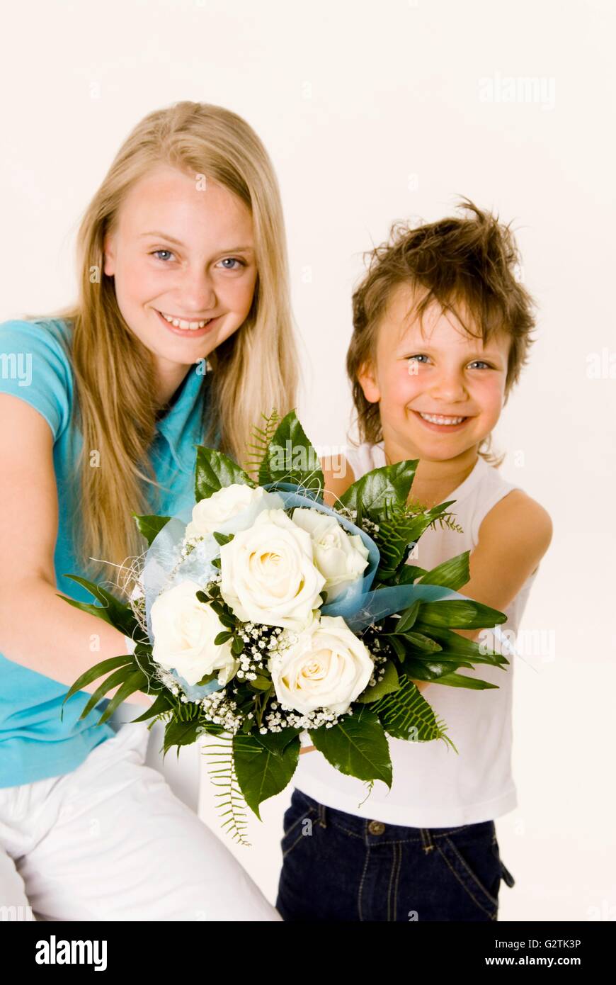 Due bambini holding bouquet di rose bianche nelle loro mani Foto Stock