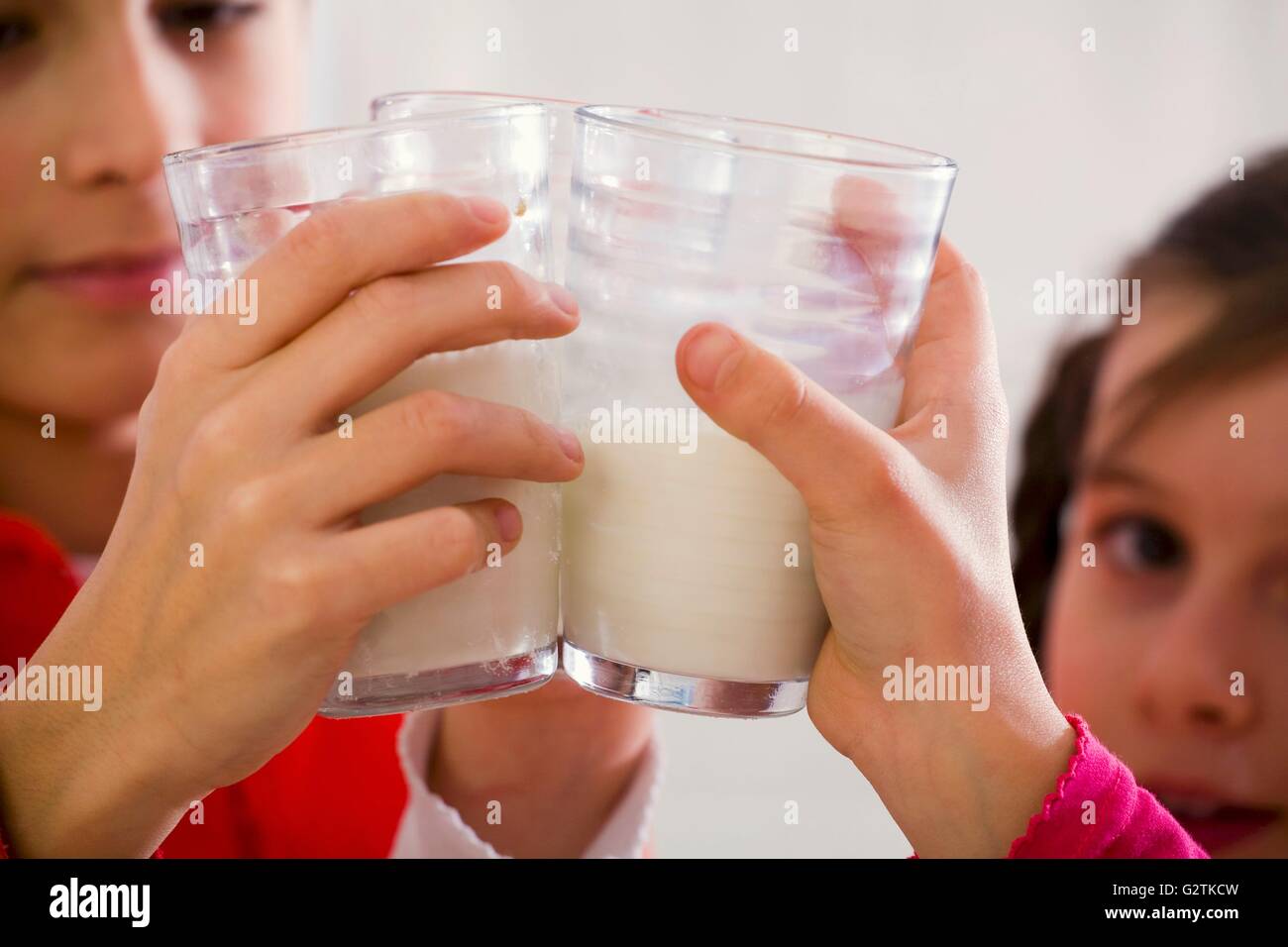 Bambini Il tintinnio di bicchieri di latte insieme Foto Stock