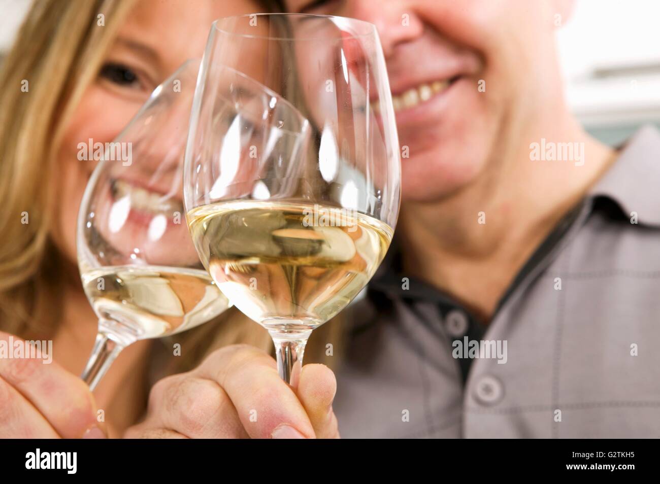 L uomo e la donna il tintinnio di bicchieri di vino bianco insieme Foto Stock