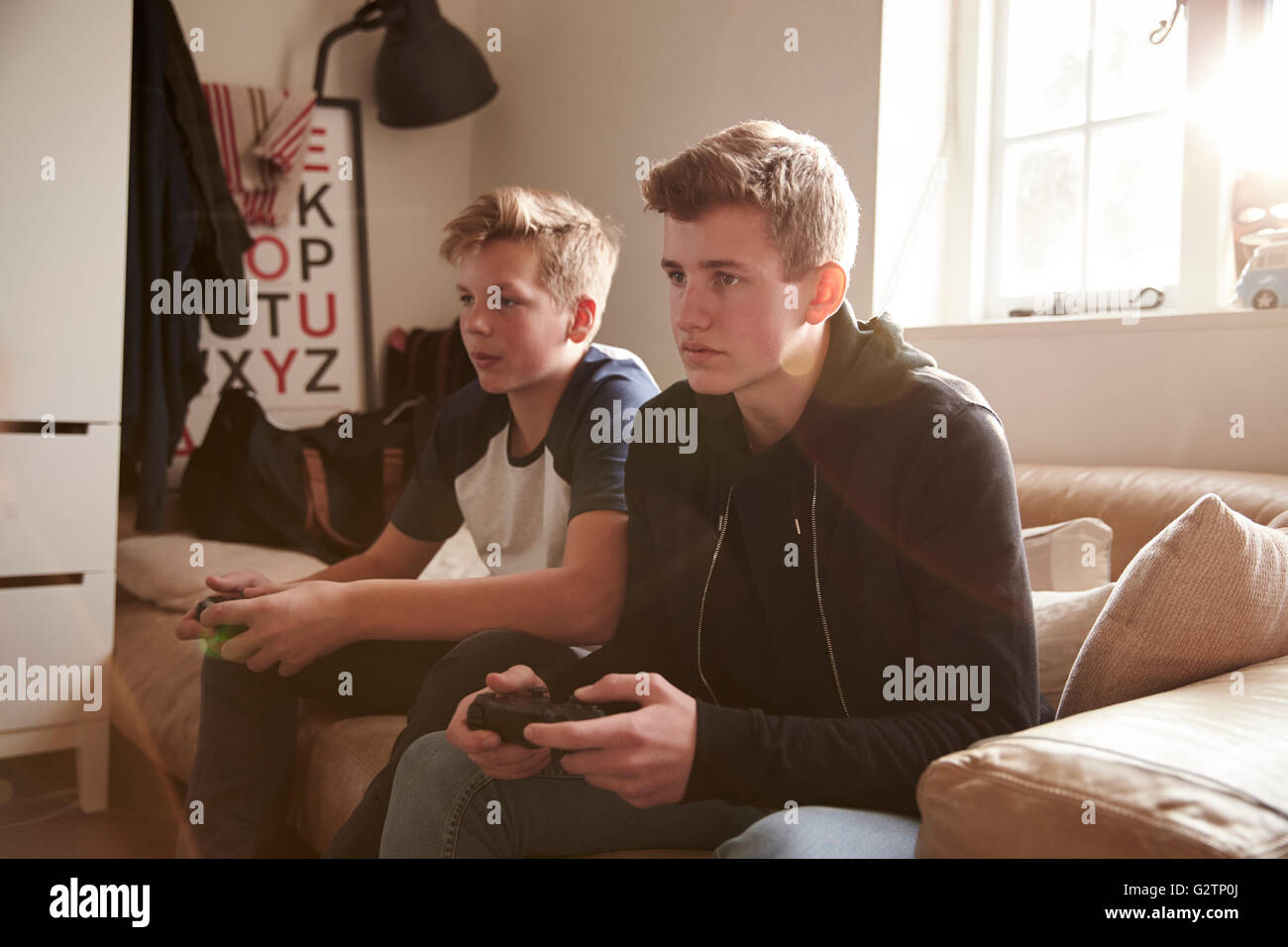 Due ragazzi adolescenti la riproduzione del video gioco in camera da letto Foto Stock