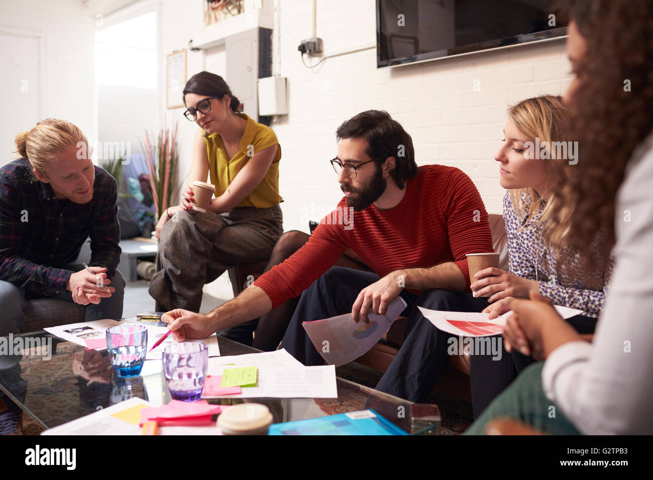 I progettisti seduto sul divano avente Riunione creativi in Office Foto Stock