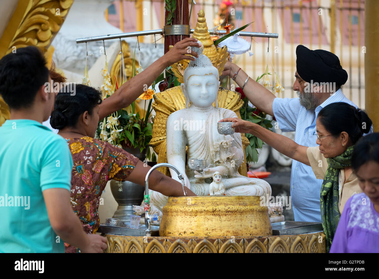 I credenti acqua versando alla statua del Buddha a Shwedagon pagoda yangon, myanmar Foto Stock