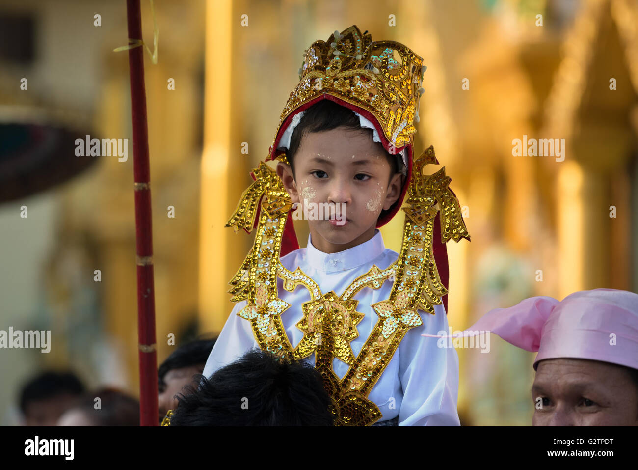 Un ragazzo su di suo padre a spalle durante un shinbyu novitiation cerimonia alla Shwedagon pagoda yangon, myanmar Foto Stock
