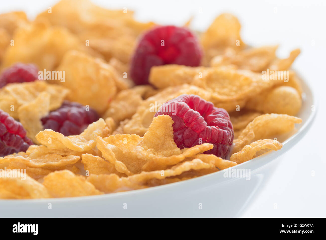 Lampone e cornflakes in una ciotola bianco Foto Stock