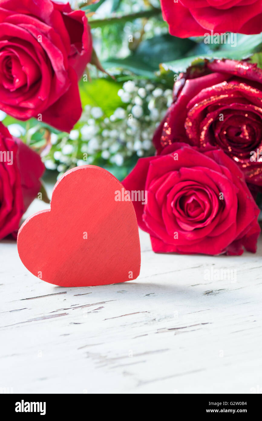 Il giorno di San Valentino con rose e cuore su un tavolo di legno. Foto Stock