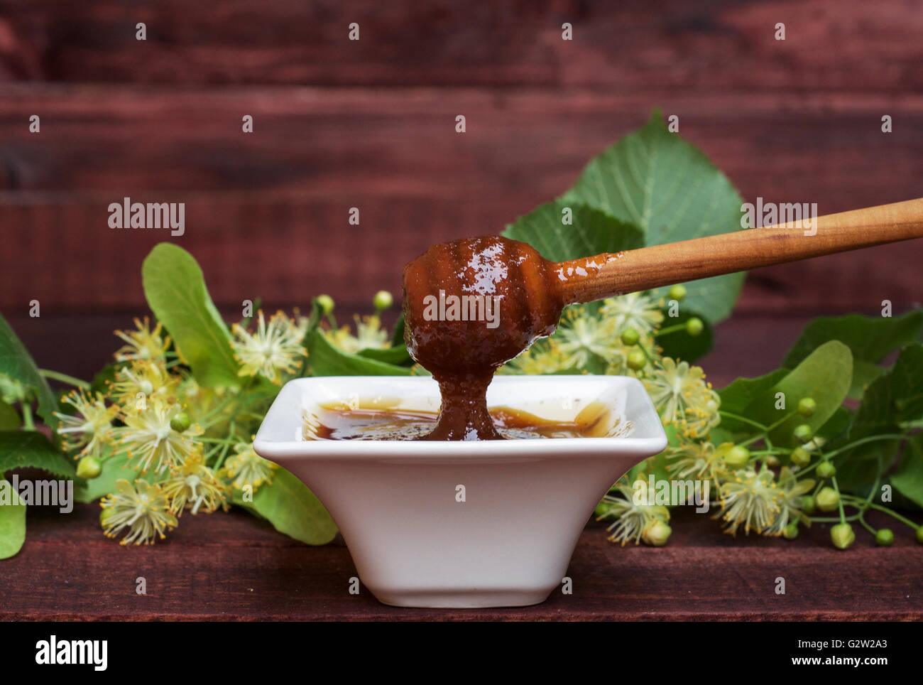 Il miele tiglio in una ciotola su una tavola di legno Foto Stock