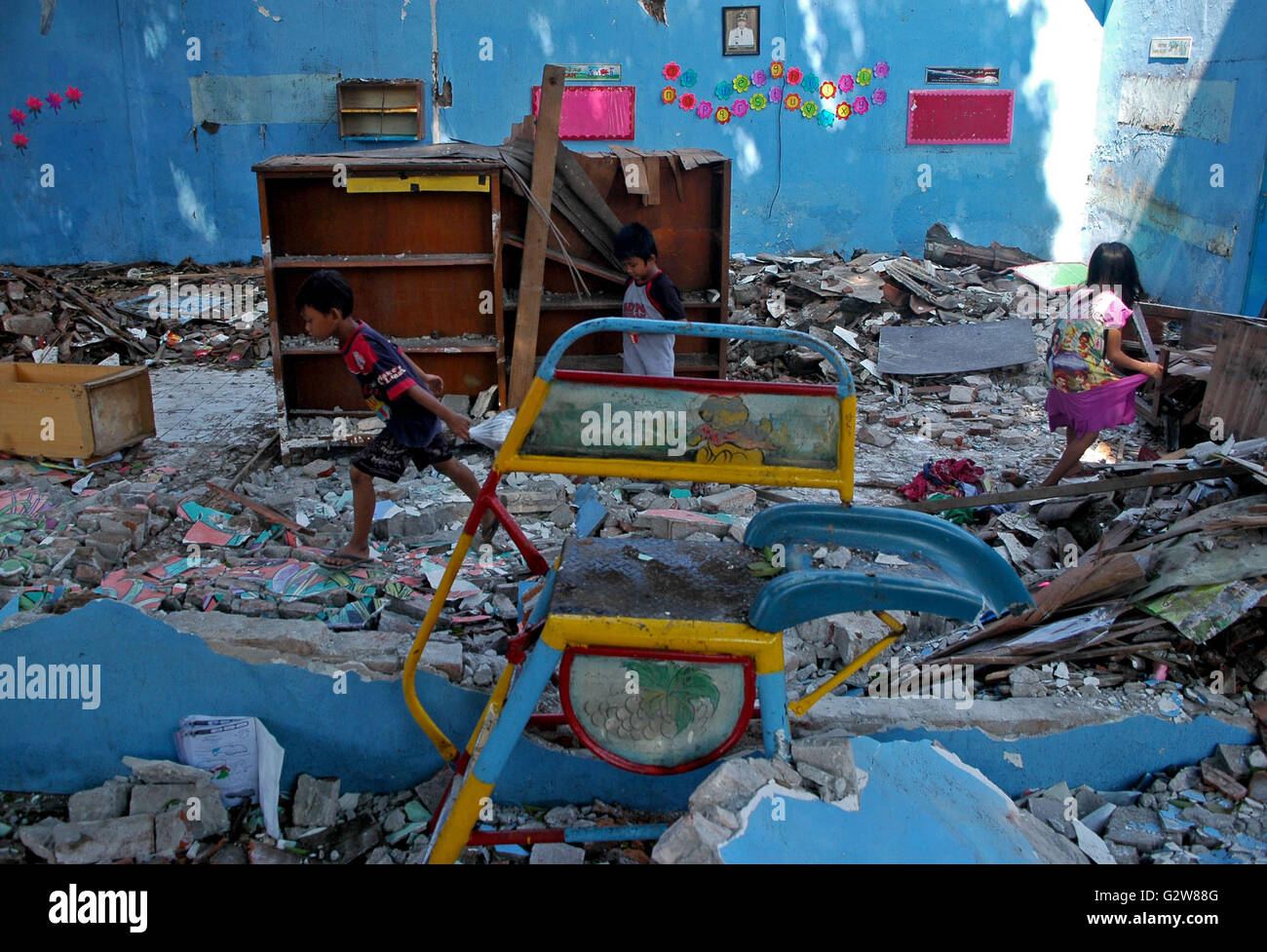 Gresik, Indonesia. Il 3 giugno, 2016. I bambini raccogliere libri e attrezzature tra le rovine del Kusuma Asilo nido a Gresik, East Java, Indonesia, 3 giugno 2016. L'edificio è crollato dopo le tempeste e le forti piogge hanno colpito Gresik giovedì. © Kurniawan/Xinhua/Alamy Live News Foto Stock