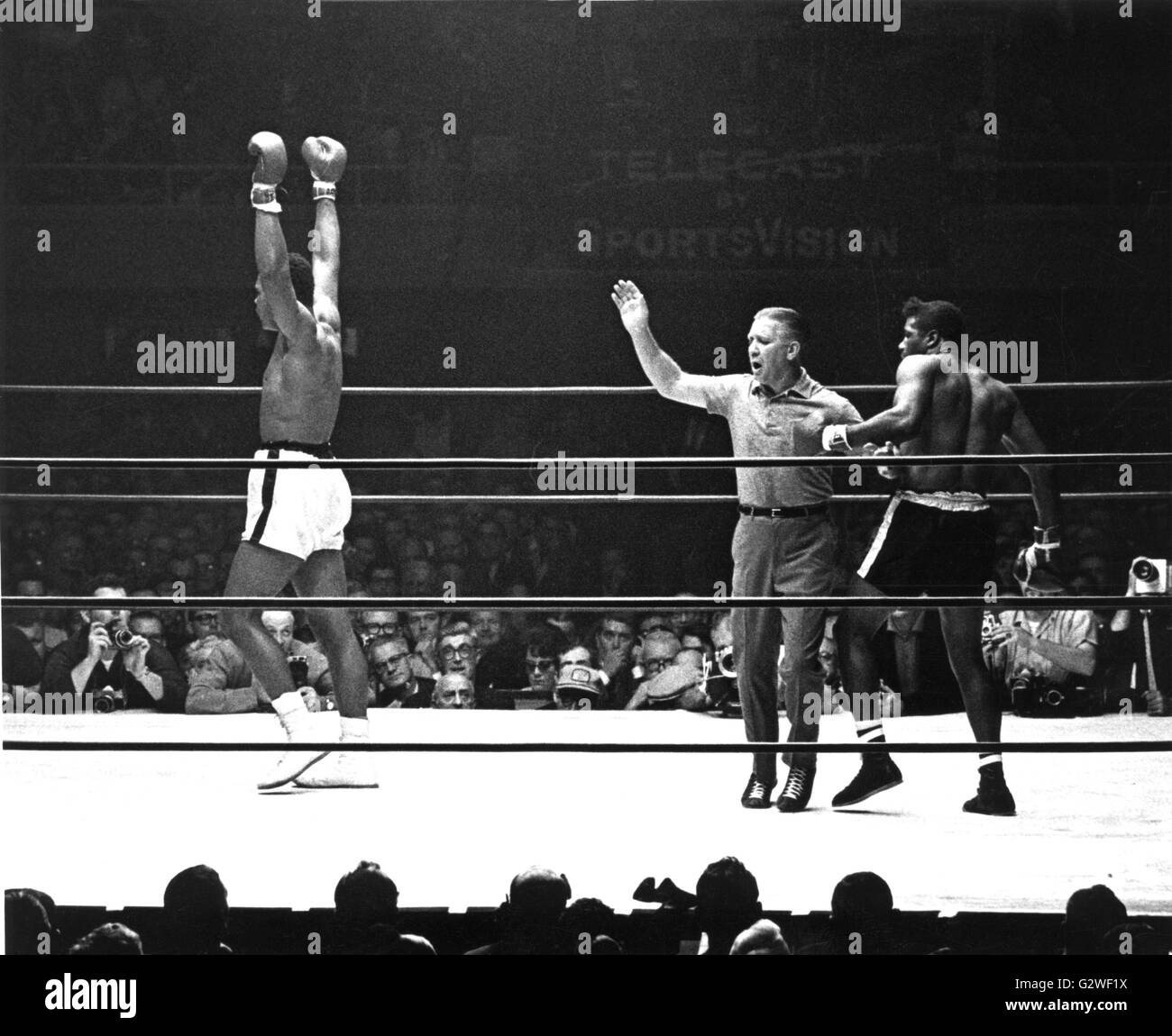 Arbitro Henry Kraus (c) trattiene sconfitto Floyd Patterson (r) mentre Muhammad Ali (ex Cassio argilla) gira verso gli spettatori. Ali sconfitto Patterson nel dodicesimo round dal knockout. | Utilizzo di tutto il mondo Foto Stock