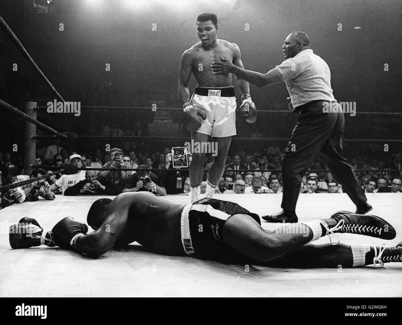 FILE - un file immagine datata 25 maggio 1965 mostra trionfante noi boxer Muhammad Ali (Cassio argilla) (C) essendo fermato da arbitro Walcott come egli guarda al suo avversario Charles 'Sonny' Liston che giace a terra durante il loro bout in Lewiston, Maine, Stati Uniti d'America. Nato Cassio argilla, boxe leggenda Muhammad Ali, soprannominato 'il più grande, ' morì il 03 giugno 2016 a Phoenix, Arizona, Stati Uniti d'America, all'età di 74, una famiglia portavoce ha detto. Foto: dpa Foto Stock