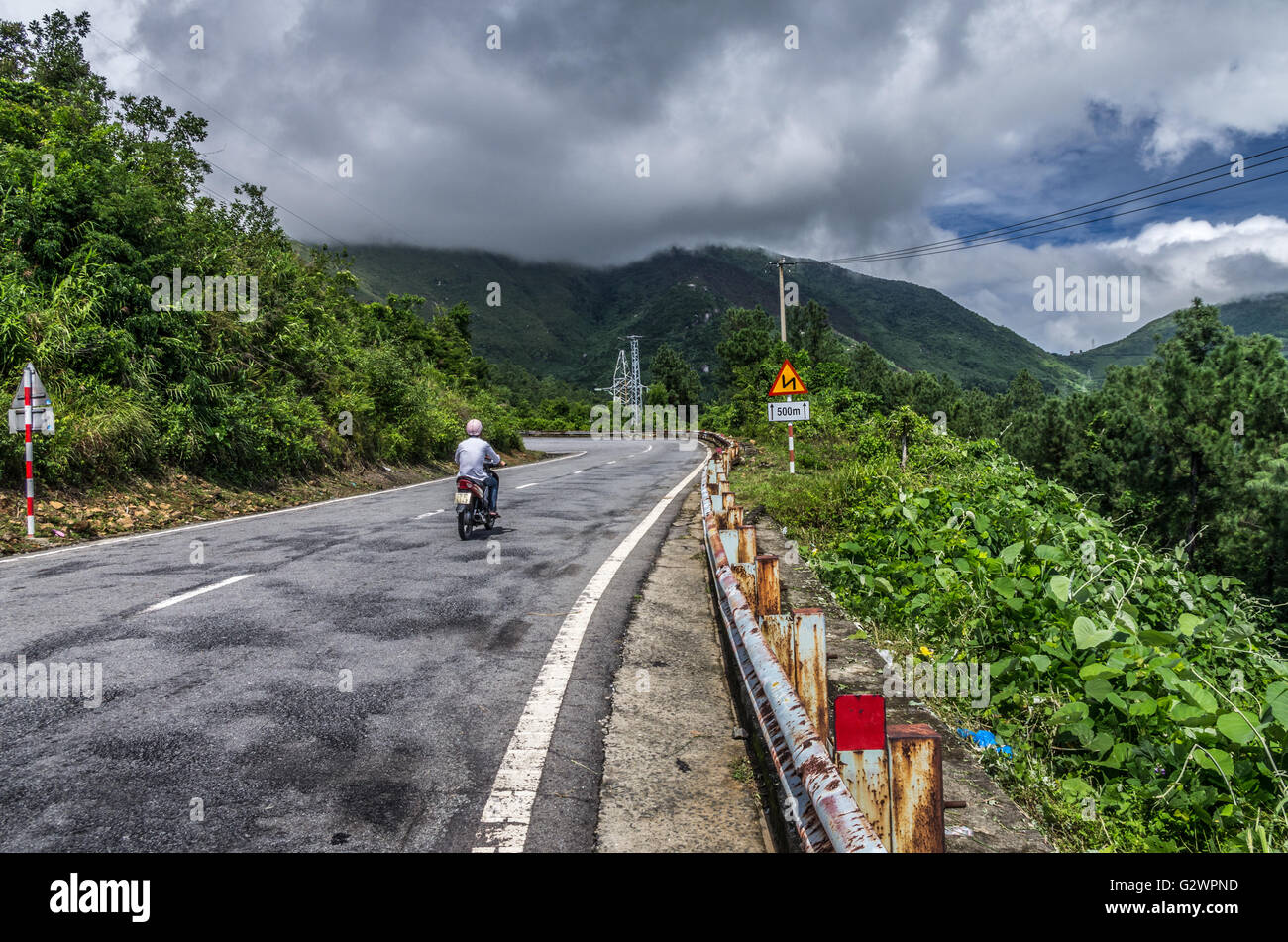 Un motociclista la scalata di Hai Van Pass nel Vietnam centrale. Foto Stock