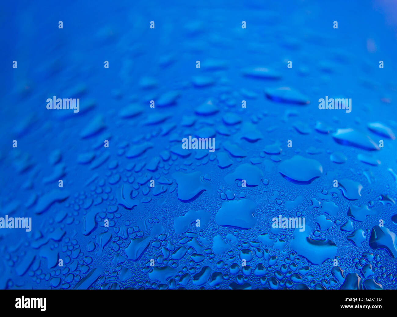 Gocce d'acqua sulla rotonda sfondo blu, soft focus, close up Foto Stock